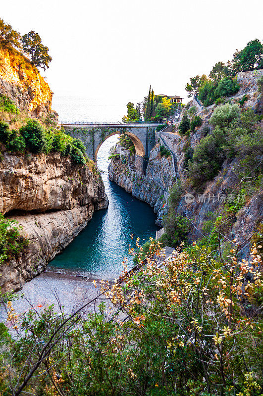 在坎帕尼亚地区的第勒尼安海湾上，在高耸的岩石悬崖之间建造的Fiordo di Furore弧形桥。弯弯曲曲的山间步道环绕着独特的自然峡谷